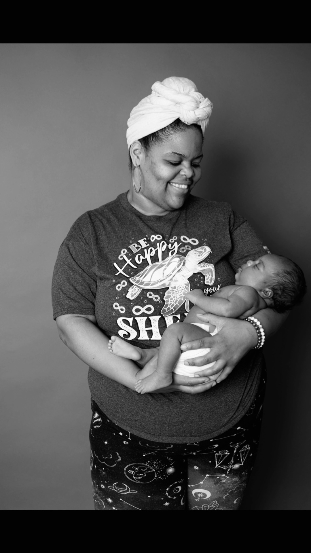 Doula smiling while holding a newborn baby