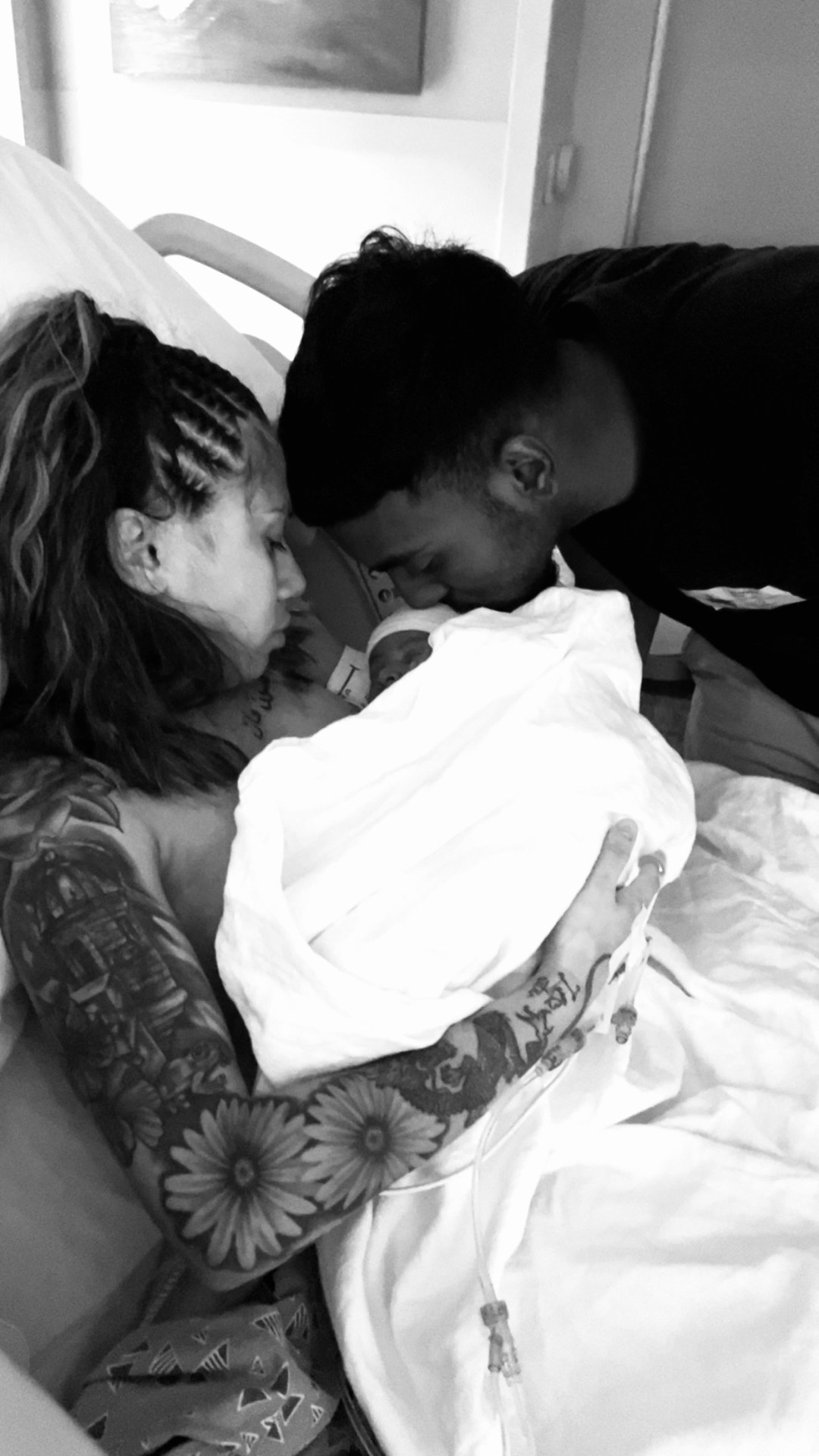 Parents tenderly holding their newborn baby